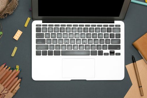 office-desk-table-with-computer-supplies-flowers-PRJPH3R